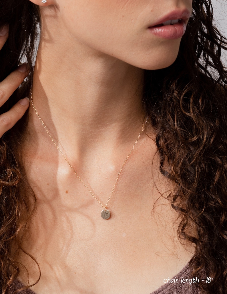 May include: A gold chain necklace with a small, round pendant. The chain is 18 inches long. The pendant is a simple, circular shape with a textured surface. The text 'chain length - 18' is visible at the bottom of the image.