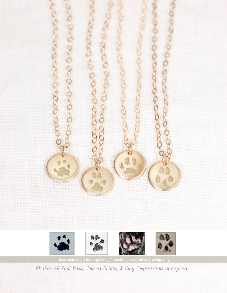 Personalized disc necklaces featuring custom engraved dog paw prints and nose prints. Each round pendant captures your pet’s unique mark in fine detail. Available in sterling silver, gold filled, or rose gold filled finishes. A meaningful keepsake or memorial gift for pet lovers, handcrafted with care and optional custom text or initials.