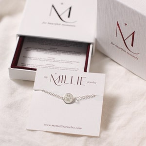 Gift-ready paw print bracelet packaged in a jewelry box. The delicate bracelet features a custom engraved pet paw print charm, displayed neatly on a soft insert with tissue or ribbon. Perfect for gifting as a personalized keepsake or memorial jewelry piece for pet lovers.