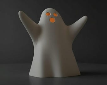 May include: A white ghost-shaped Halloween decoration with outstretched arms and three orange eye holes. The ghost is made of a smooth material and sits on a dark surface. The interior of the eye holes glows with an orange light.
