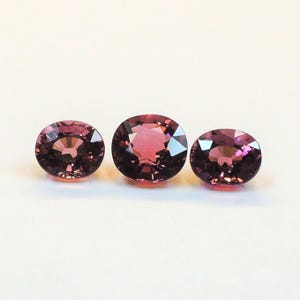 Raspberry pink tourmaline, this trio of oval and purplish-pink cushion-cut gems weighs 3.56 carats and comes from Africa image 9
