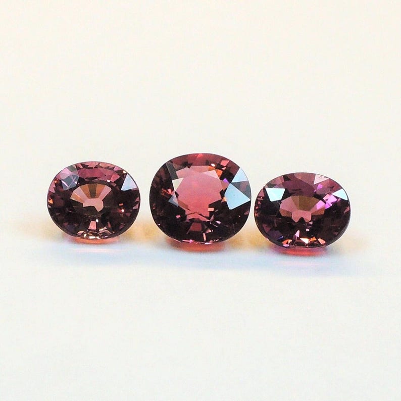 Raspberry pink tourmaline, this trio of oval and purplish-pink cushion-cut gems weighs 3.56 carats and comes from Africa image 9
