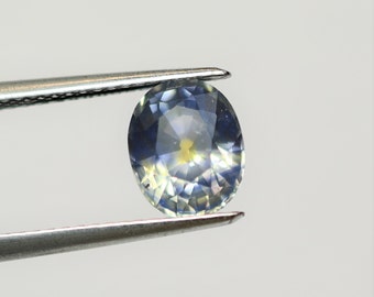 Smoky oval sapphire 8.5x6.8, this large cloudy blue gray corundum with yellow central spot weighs 2.52 carats and comes from Sri Lanka