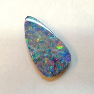 Large doublet of rainbow opal with a pin point pattern; this long, multicoloured pear-shaped stone measures 13x25 mm, weighs 7.27 carats and originates from Australia.
