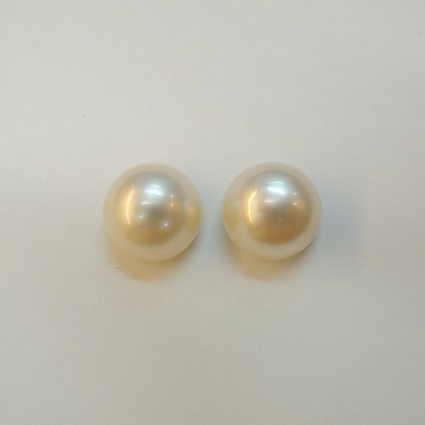 Mabe 14 mm creamy white, this pair of half cultured beads has a beautiful luster and shows a little dispersion