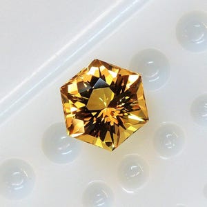 A very bright golden yellow hexagonal citrine, this fancy cut gem from Brazil weighs 3.68 carats and measures 9.6 mm