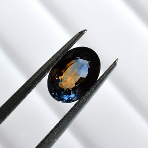 Bi-color blue and orange sapphire, this oval corundum measures 7.9x5.6 mm, weighs 1.62 carats and comes from Madagascar