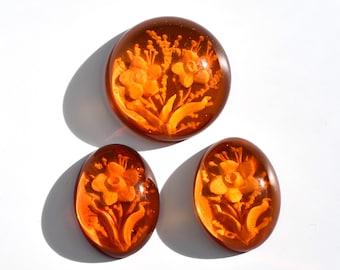 Polish amber with intaglio, carved amber cabochons oval 15x20 and round 22 mm, this trio with bouquet of flowers motif weighs 23.30 carats