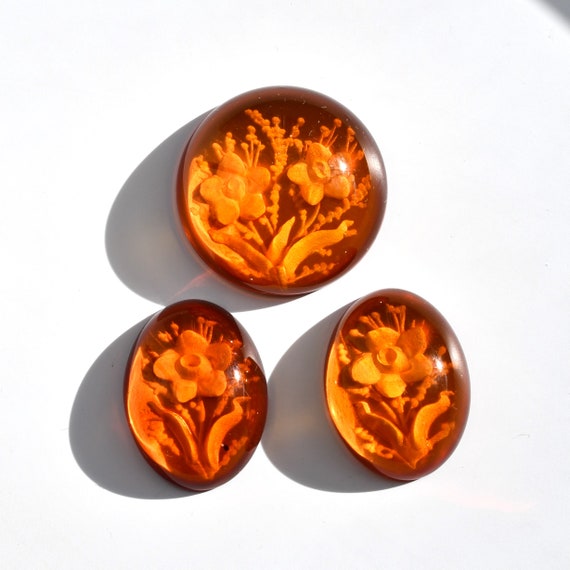 Ambre de Pologne avec intaglio, cabochons d'ambre sculpté ovale 15x20 et rond 22 mm, ce trio avec motif bouquet de fleurs pèse 23.30 carats