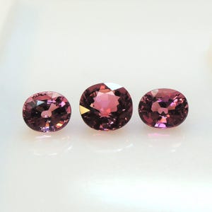 Raspberry pink tourmaline, this trio of oval and purplish-pink cushion-cut gems weighs 3.56 carats and comes from Africa image 8