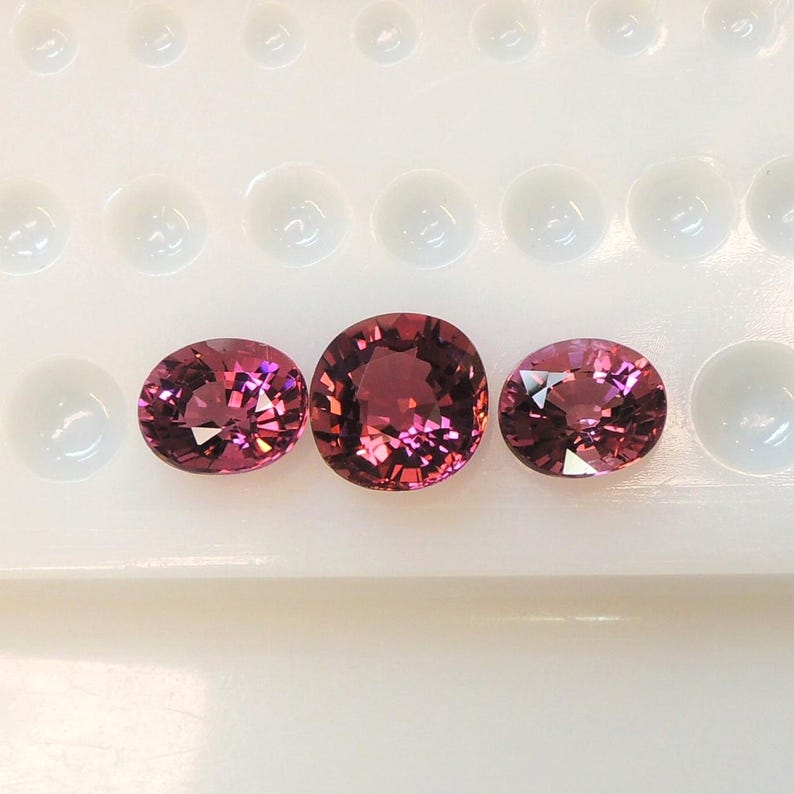 Raspberry pink tourmaline, this trio of oval and purplish-pink cushion-cut gems weighs 3.56 carats and comes from Africa image 5