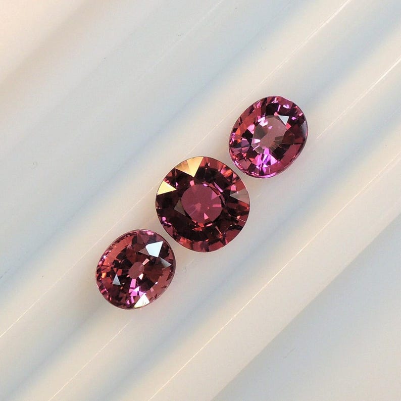 Raspberry pink tourmaline, this trio of oval and purplish-pink cushion-cut gems weighs 3.56 carats and comes from Africa image 4