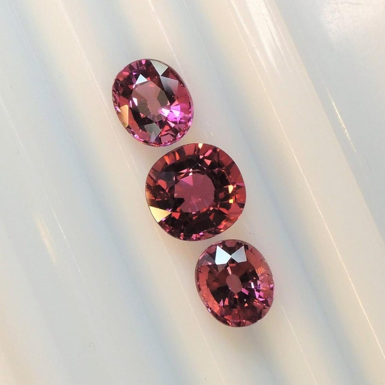 Raspberry pink tourmaline, this trio of oval and purplish-pink cushion-cut gems weighs 3.56 carats and comes from Africa image 2