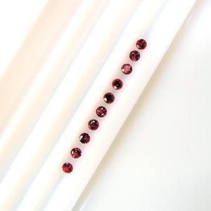 Rubis absolument rouge, rond 2.5 à 2.6 mm, ce lot de 10 pierres transparentes pèse 1.07 carat et provient d'Afrique