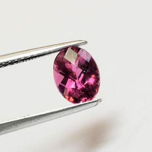 This oval raspberry pink tourmaline, measuring 8x6 mm, is cut in a checkerboard pattern, weighs 1.14 carats, and comes from Brazil.