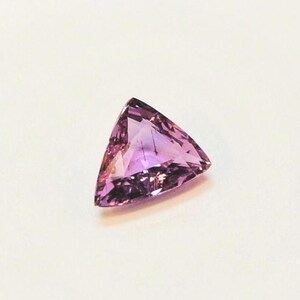 Triangular or trillion asymmetrical pinkish-purple sapphire, 5.7x6.5 mm, this flat stone weighs 0.84 carats