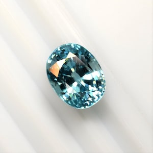 Large oval zircon, 11x9 mm, this blue-green stone is well-cut, deep, weighs 7.46 carats, and comes from Cambodia.