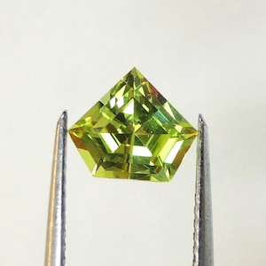 Chrysobéryl vert pomme coupe bouclier ou pentagone, cette pierre vert lime limpide et étincellante mesure 7.3x8.4 mm et pèse 1.47 carat
