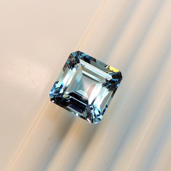 Topaz Asscher 12 mm, this large emerald cut square gem weighs 10.27 carats, it is an irradiated stone that comes from Brazil