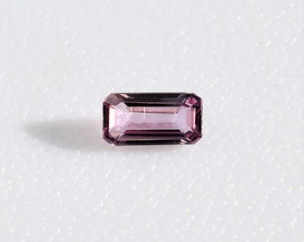 Emerald cut pastel pink purple sapphire 3.6x7.0 mm, this pale plum colored octagonal corundum weighs 0.65 carat