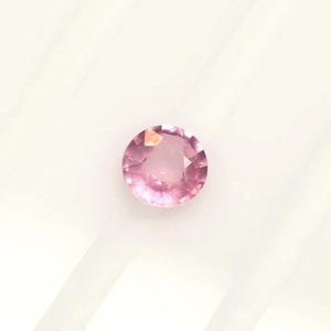 Pink spinel 5.4 mm round, this milky stone of a soft sleepy pink weighs 0.63 carat and comes from Tanzania