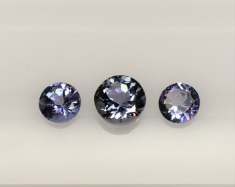 Tanzanite trio round 5 mm and 4 mm, the pair of zoisite is bluish purple but the central stone is greenish purple, this lot weighs 1.08 carat