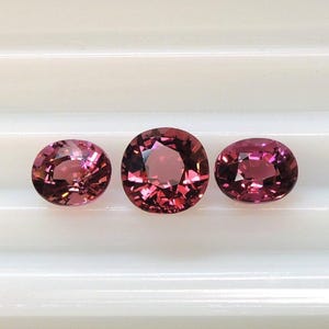 Raspberry pink tourmaline, this trio of oval and purplish-pink cushion-cut gems weighs 3.56 carats and comes from Africa image 1