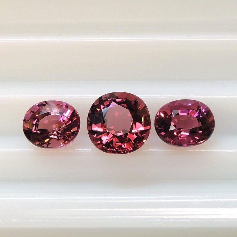 Raspberry pink tourmaline, this trio of oval and purplish-pink cushion-cut gems weighs 3.56 carats and comes from Africa image 1