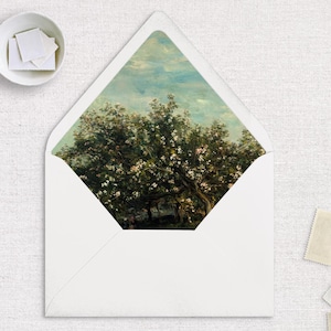 May include: A white envelope with a floral design on the flap. The design features a painting of a tree with pink blossoms against a blue sky.