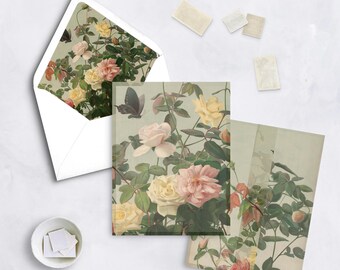 May include: Stationery set featuring floral rose illustrations in shades of pink, yellow, and white, with green foliage and butterflies. Includes an envelope, notecards, and stamps, all with a vintage aesthetic.
