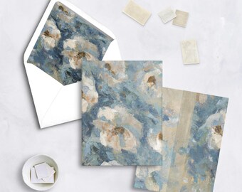May include: Stationery set featuring an abstract floral design in shades of blue, white, and beige. The set includes an envelope, notecards, and stamps. The envelope's interior and the notecards display the same painted floral pattern.
