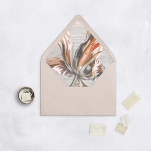 May include: A light gray envelope with a floral design on the inside flap. The design features a large, stylized tulip in shades of brown, orange, and gray.