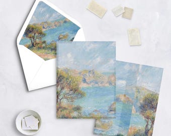 May include: Stationery set featuring a landscape painting of a coastal scene with blue water, green trees, and a light blue sky. Includes an envelope, notecards, and stamps. The artwork has a textured, impressionistic style.