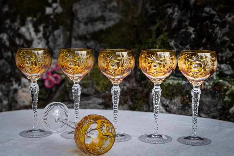 Puede incluir: Juego de seis copas de vino de cristal &aacute;mbar con intrincados dise&ntilde;os tallados. Las copas tienen una copa redonda y un tallo largo y delgado.