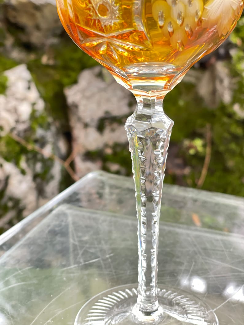 Puede incluir: Una copa de vidrio transparente con un dise&ntilde;o de cristal tallado. La copa est&aacute; llena de un l&iacute;quido &aacute;mbar dorado. El tallo de la copa es texturizado y tiene un patr&oacute;n de diamante.