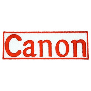 May include: Red embroidered patch with the word "Canon" in white lettering.