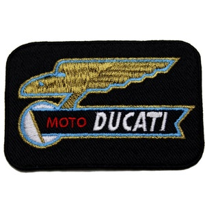 Może przedstawiać: Czarna, haftowana naszywka z napisem "MOTO DUCATI" w kolorze białym i czerwonym oraz złotym i niebieskim motywem orła. Naszywka jest prostokątna z zaokrąglonymi rogami, idealna na kurtki lub torby.