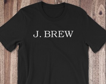 Op de afbeelding: Zwart T-shirt met witte tekst "J. BREW".