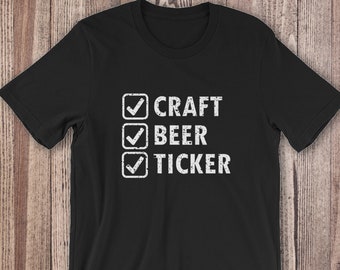 Puede incluir: Camiseta negra con un gráfico de lista de verificación blanca que dice "CRAFT BEER TICKER" con marcas de verificación junto a cada elemento.