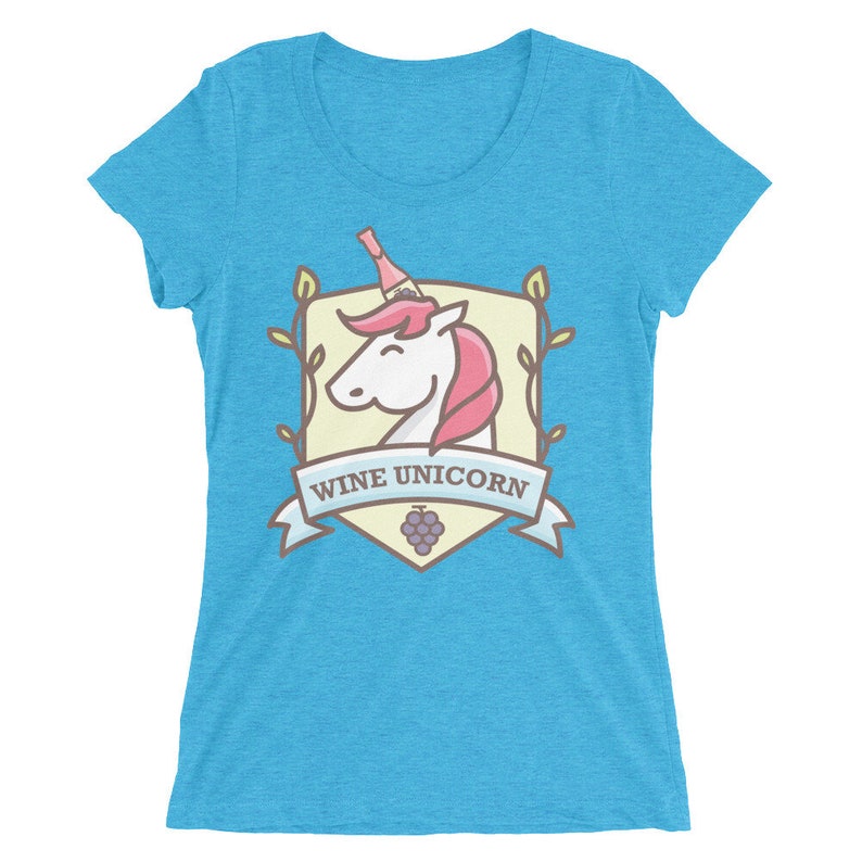 Puede incluir: Una camiseta de mujer azul turquesa con una ilustraci&oacute;n de dibujos animados de un unicornio con una botella de vino en la cabeza. La ilustraci&oacute;n est&aacute; rodeada de un escudo con el texto "Wine Unicorn".