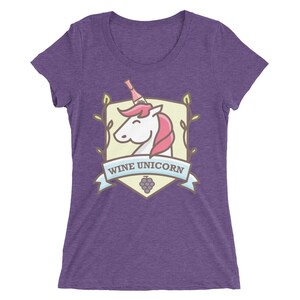 Puede incluir: Camiseta morada para mujer con un gr&aacute;fico de un unicornio con una botella de vino en la cabeza. El gr&aacute;fico est&aacute; dentro de un escudo con el texto "Wine Unicorn".