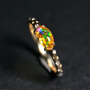 Anillo de compromiso de oro amarillo de 14 quilates con ópalo de fuego mexicano y diamantes.