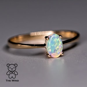 Op de afbeelding: Een delicate gouden ring met een witte opaal edelsteen. De opaal heeft een subtiele, iriserende glans.