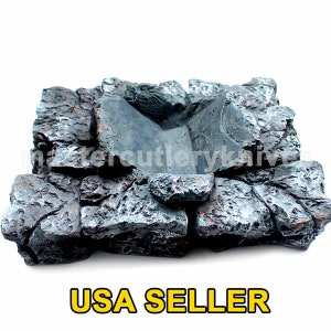 May include: A decorative, miniature rock formation with a central basin. The piece is primarily gray with hints of orange and brown, and the text "USA SELLER" is displayed in yellow.