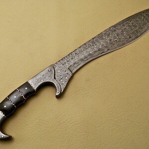 May include: A silver-colored, Damascus steel sword with a black handle. The blade is curved and has a decorative pattern. The handle is made of wood and has a black finish.