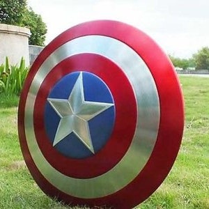 May include: A red, white and blue Captain America shield with a silver star in the centre. The shield is made of metal and has a glossy finish.