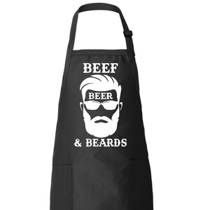 May include: Black apron with a white graphic of a bearded man wearing sunglasses and the text "Beef Beer & Beards".