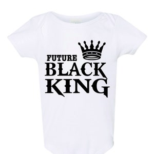 Può includere: Body bianco per neonato con testo nero che recita "Future Black King" e una corona nera sopra il testo.
