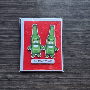 May include: A red greeting card with a white border and a white banner that says "It's Party Time!"  Two green cartoon beer bottles with faces are holding hands. The background is red with white stars.