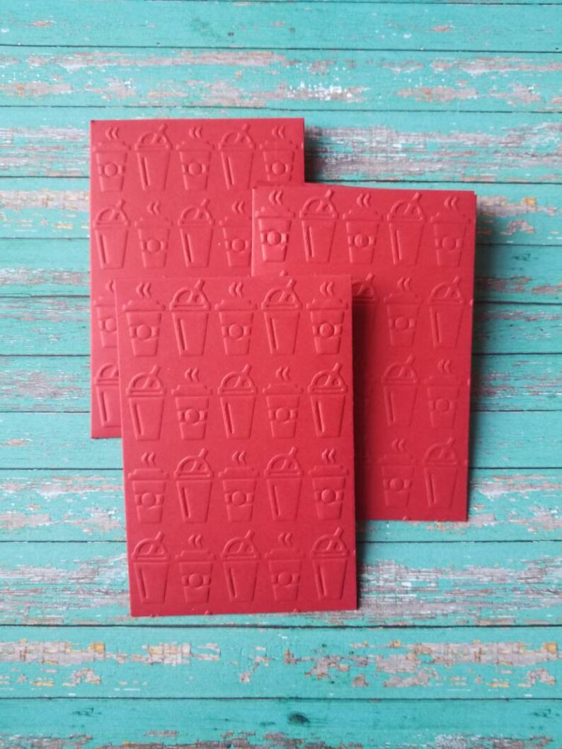 May include: Four red cards with a repeating pattern of coffee cups. The cups are embossed and have steam coming from the top.